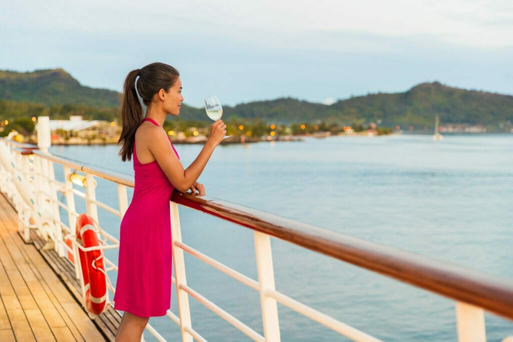 femme dégustant un verre de vin blanc sur le pont du paquebot lors d'une croisière luxueuse à Tahiti, Polynésie Française