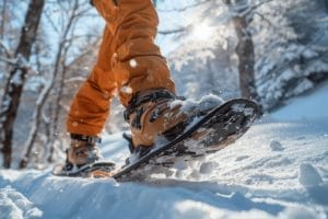 Pied en bottes de randonnée marchant dans la neige fraîche